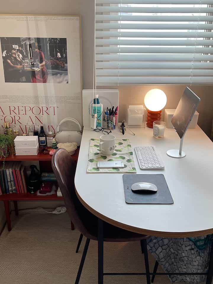 ホワイト天板と木目の縁が調和した半楕円形テーブルとブラウンチェアが置かれた落ち着いたナチュラルトーンのダイニングルーム