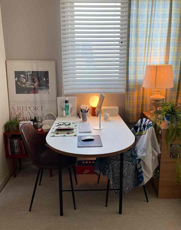 ホワイトと木目調の調和が取れたホームオフィス空間、北向きの窓のそばに配置されたダイニングテーブルと椅子が暖かな雰囲気を演出