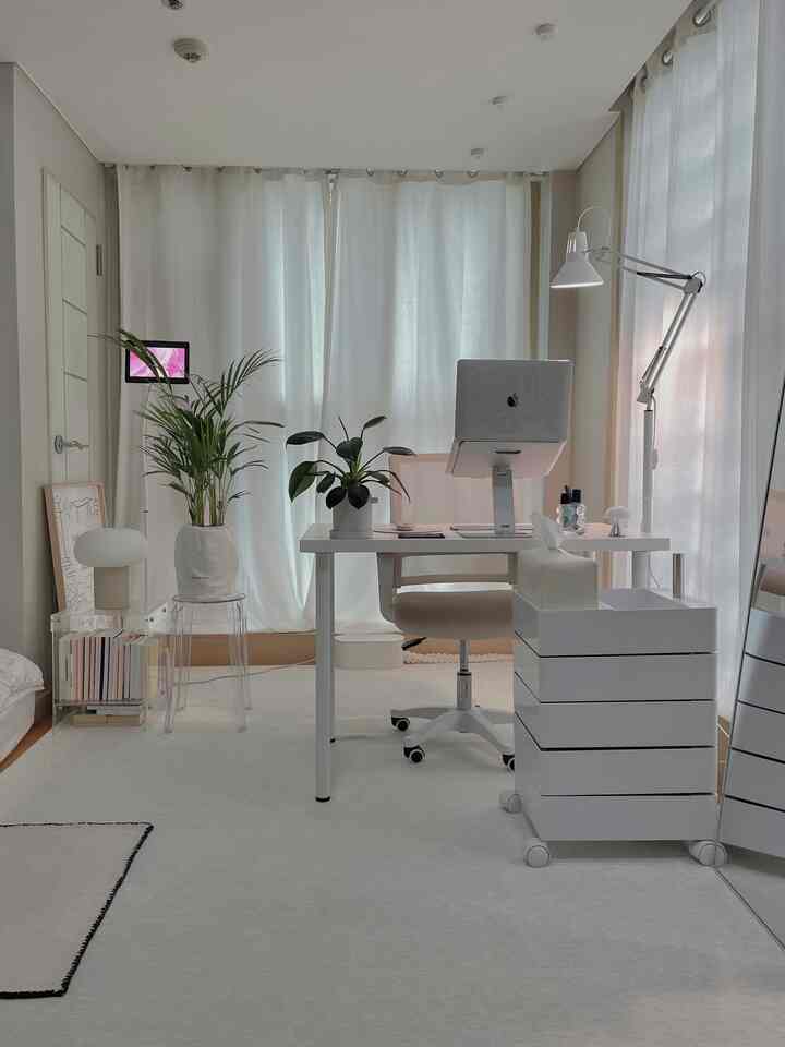 明るいホワイトと透明な家具が調和したミッドセンチュリーモダン風のホームオフィス空間、中央に配置されたデスクとオフィスチェアが特徴的なインテリア