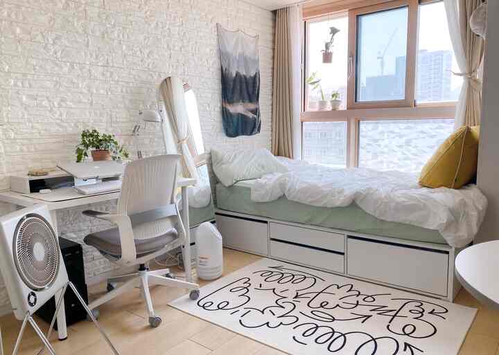 白と緑のトーンの寝室、机とベッドが配置された清潔で自然な雰囲気のインテリア