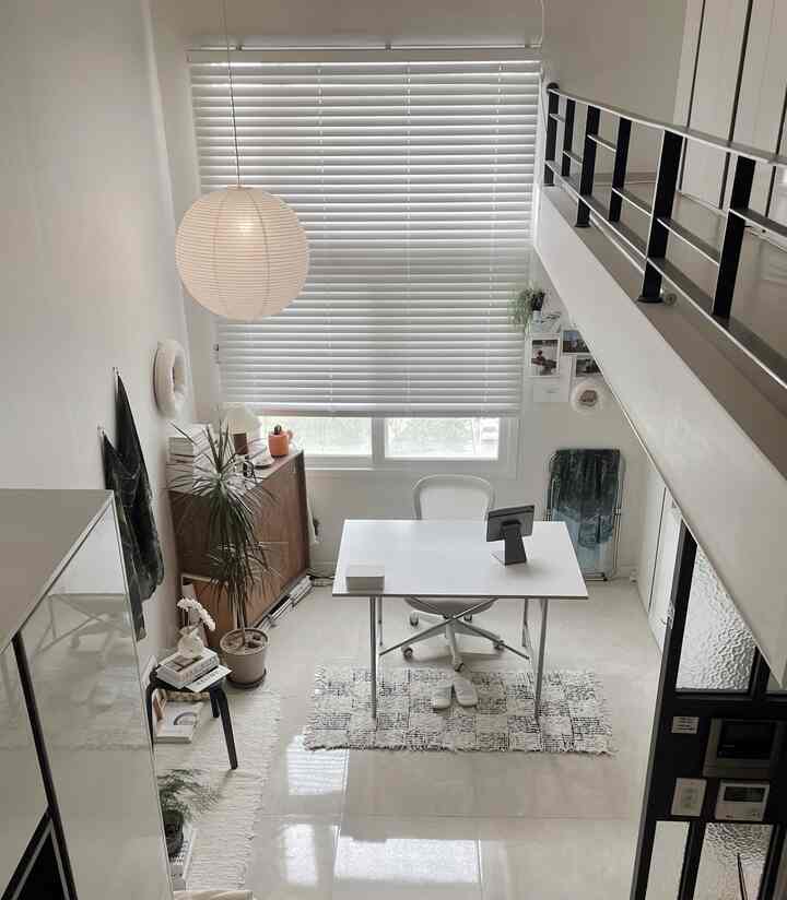 白と木目調が調和したモダンなホームオフィス、ブラインドが配置された狭く明るい作業空間
