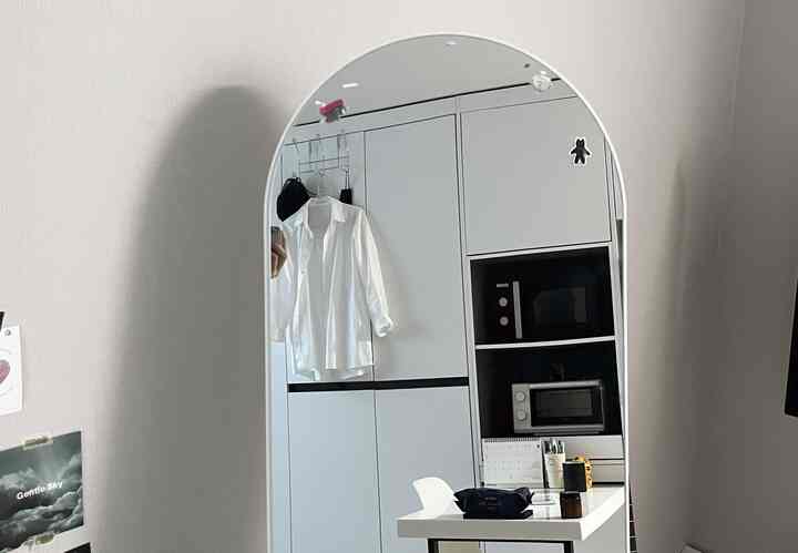 柔らかな曲線のアーチ型ホワイト全身鏡とキッチン家具が調和したシンプルで清潔感のある空間