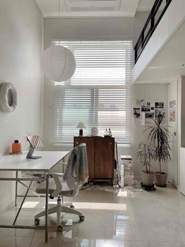 ホワイトとウッドトーンの調和が美しいホームオフィス、ブラインドと植物が温かみのあるシンプルモダンな雰囲気を演出