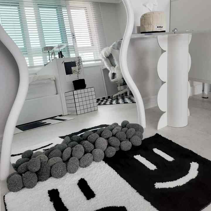 白と黒の調和がある6畳の部屋に曲線型の全身鏡とラバーストーンが配置されたミッドセンチュリーモダンのインテリア