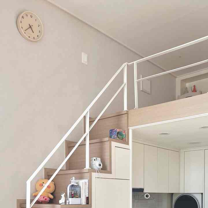 白と木目調の調和が美しい階段とロフトがあるシンプルでミニマルなインテリア