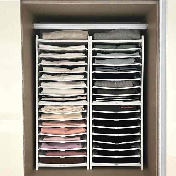 白を基調としたクローゼットに整理された衣類収納トレイが配置された清潔感のあるモダンなインテリア