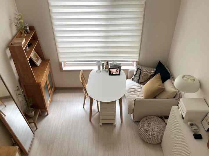 ナチュラルな色調のコンパクトなリビング、木製家具と白いソファが調和した居心地の良い一人暮らしの空間