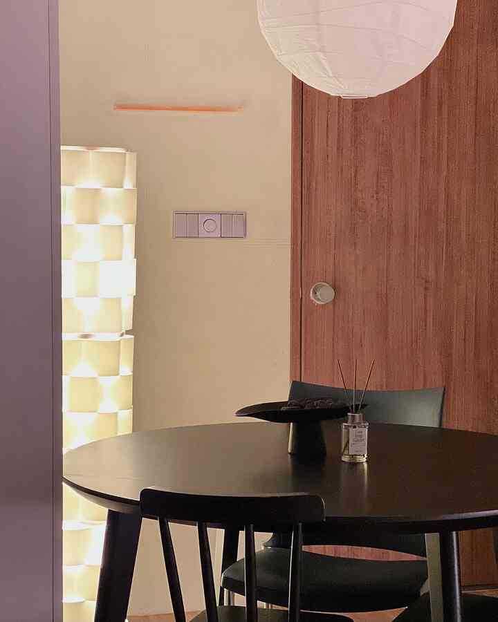 ベージュのダイニングルームにブラックのダイニングテーブルと椅子が配置された、ナチュラルで落ち着いた雰囲気のインテリア