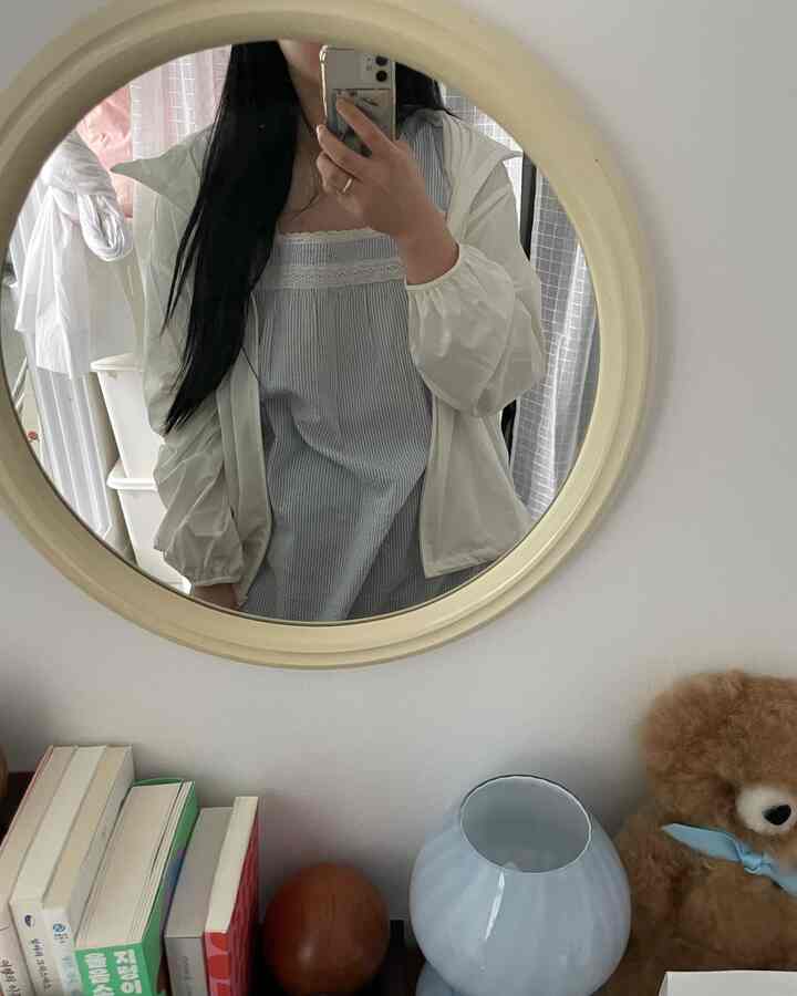 バターイエローのヴィンテージ丸型鏡とチェストが配置されたナチュラルトーンの子供部屋