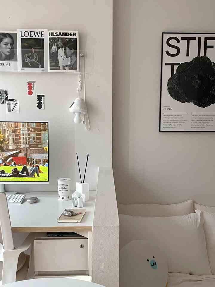ホワイトとアイボリー調のコンパクトな一人暮らしのワークスペースと寝室が仕切られたモダンなインテリア