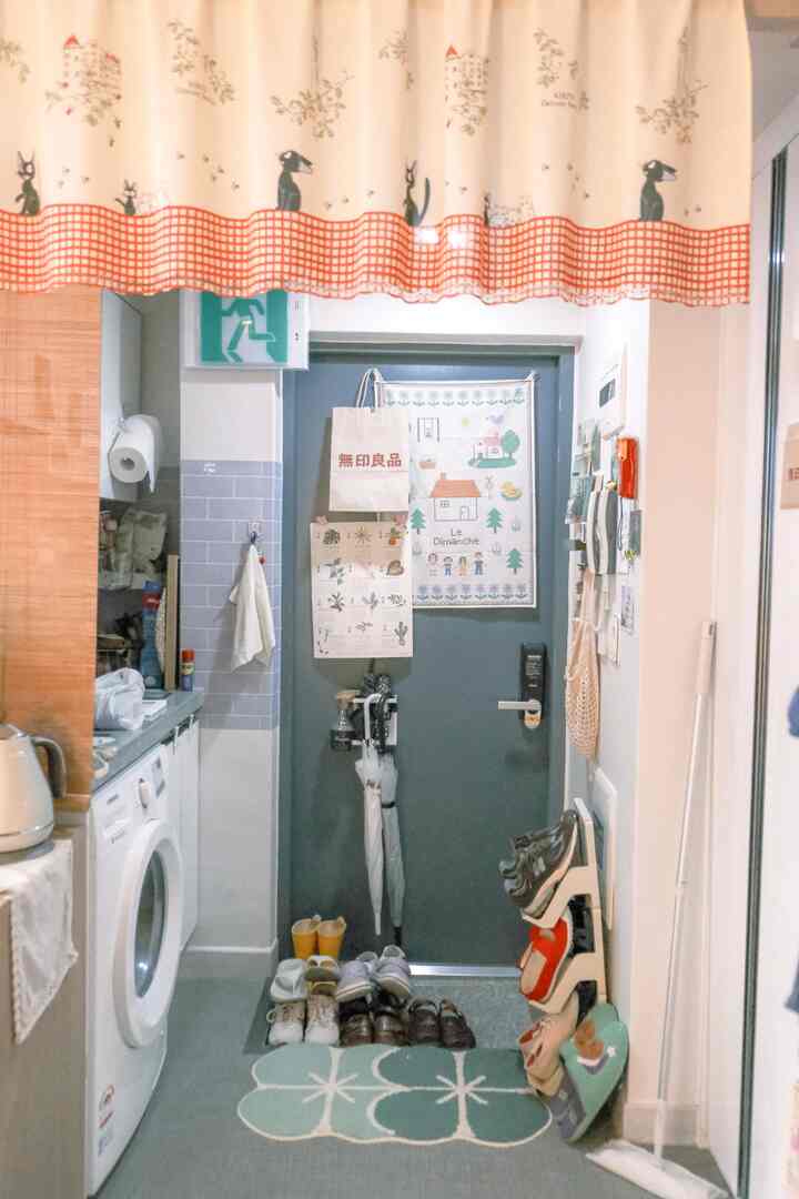 白と青の色調のワンルーム玄関、整理されたシューズラックと靴が配置された居心地の良いコンパクトな空間