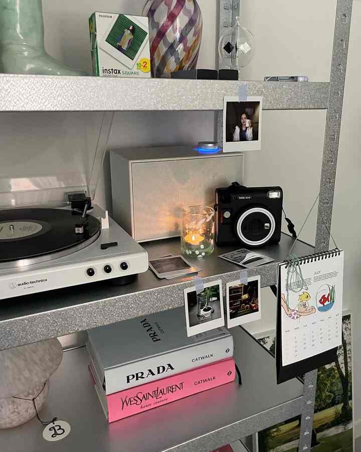 白とメタリックの色調の書斎、金属製の棚にターンテーブルとブルートゥーススピーカー、ヴィンテージ小物が配置された雰囲気のあるインテリア