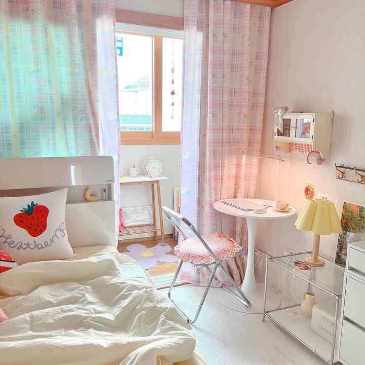 パステルピンクの寝室空間、花柄カーテンと丸テーブルが配置された雰囲気のあるヴィンテージインテリア