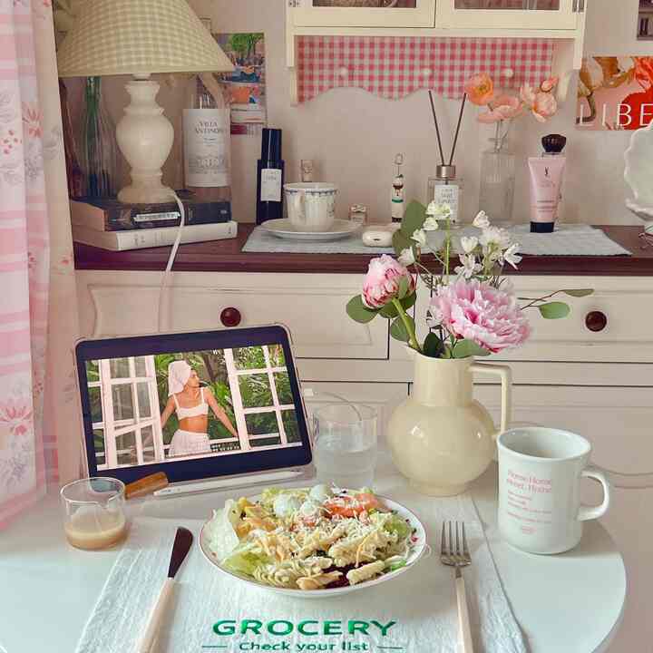 白とベージュの色調のホームカフェ空間、花瓶とダイニングセットが配置された雰囲気のあるインテリア