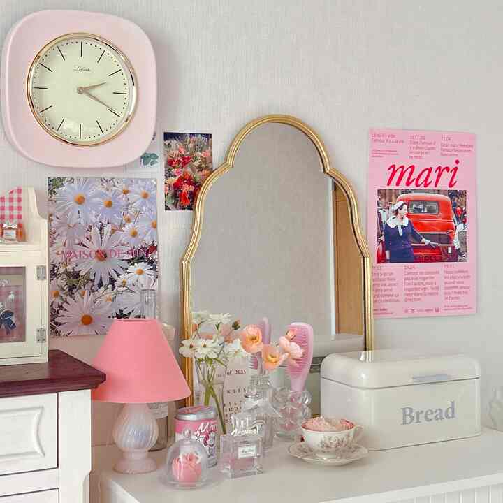 ホワイトとピンクの色調の空間、ヴィンテージ風の鏡と化粧台が配置された雰囲気のあるインテリア