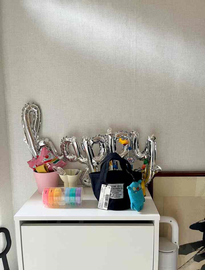 白を基調とした玄関スペース、すっきりしたシューズラックと外出用品が整理されたシンプルな収納インテリア