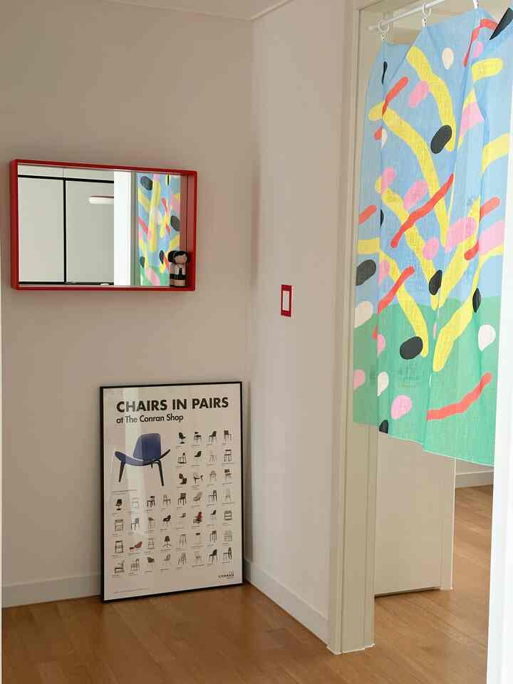 ウッドトーンの床と白い壁が調和した子供部屋、明るくカラフルなカーテンとポスターが配置された雰囲気のあるインテリア