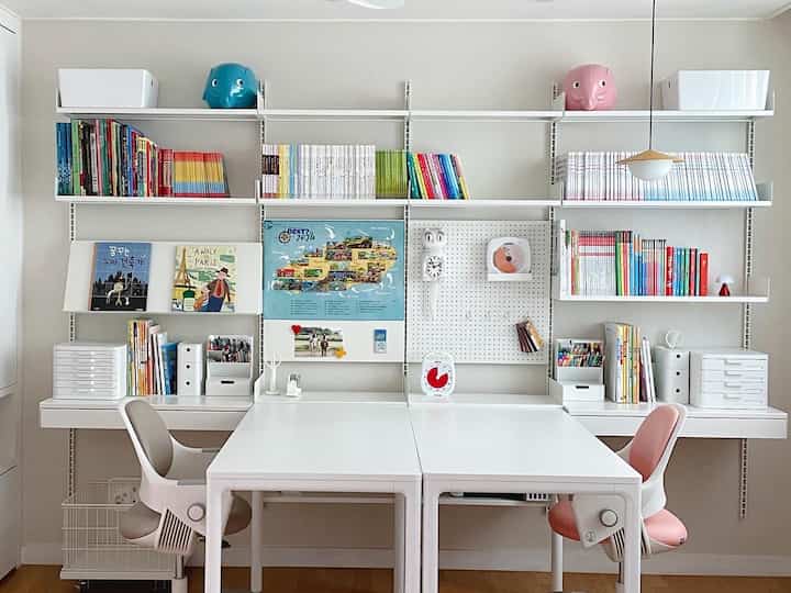 ホワイトとナチュラルトーンの子供部屋、2つのデスクとチェアが配置された清潔でミニマルな勉強空間