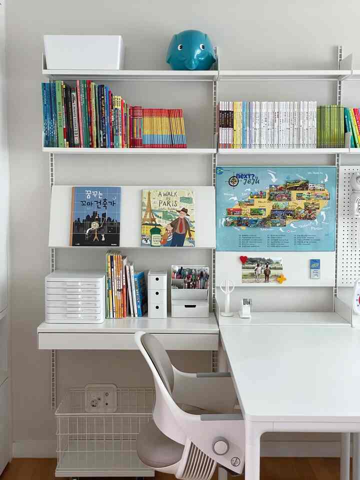 白を基調とした子供部屋、棚と机が配置された整った機能的な学習空間