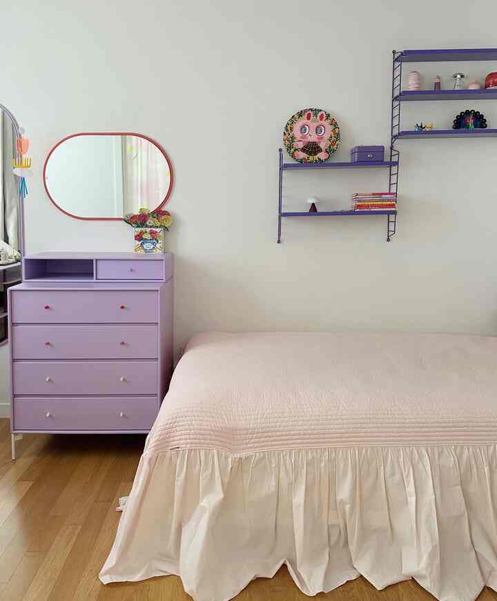 白い壁とラベンダー色のチェストがある赤ちゃんと子供用の子供部屋、シンプルでナチュラルな雰囲気のインテリア
