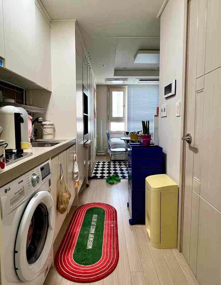 白を基調としたキッチンとオフィス텔の玄関、ビルトインクローゼットが配置された落ち着いたコンパクトな空間