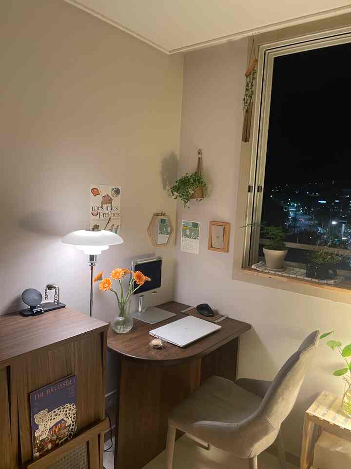 暖かみのあるブラウンとホワイトのトーンが調和したナチュラルなホームオフィス、木製家具と植物が配置された雰囲気のある空間