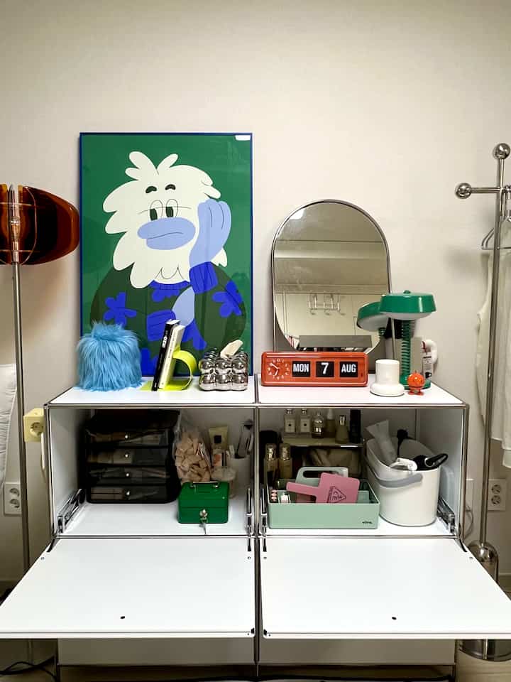 白いキャビネットとミント色のツールボックスが配置されたワンルームの整然とした空間