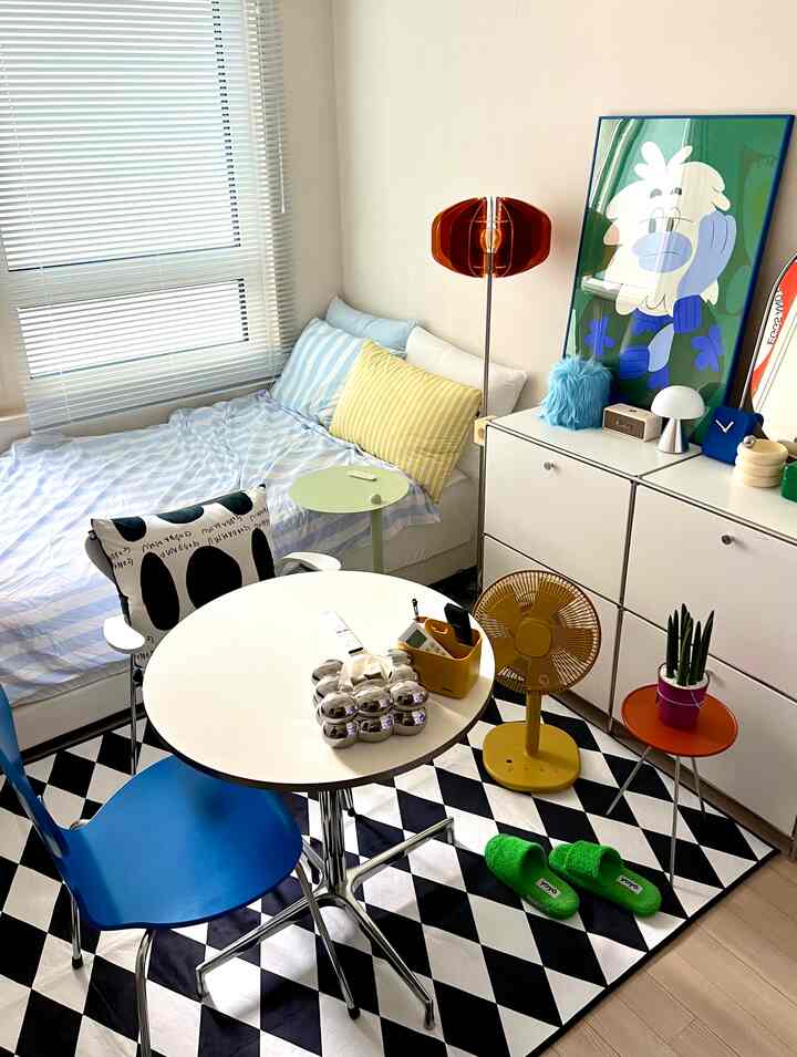 白と青のトーンのワンルームキッチン、モダンな家具とカラフルな小物が配置された雰囲気のある空間