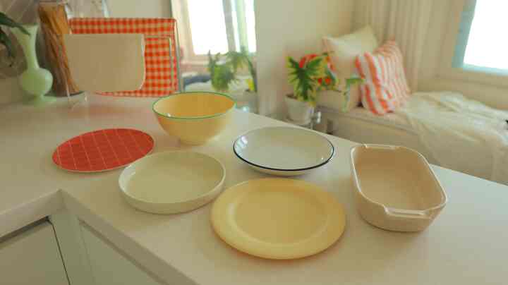 黄色と白を基調としたキッチンカウンターに様々なボウルが配置された、自然な雰囲気のある空間