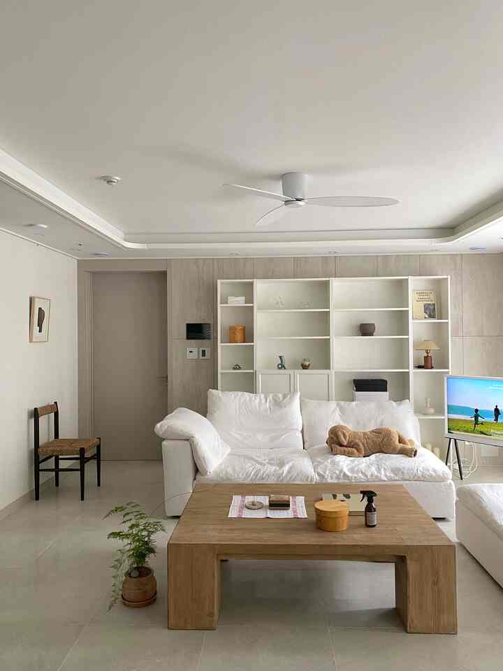 白と木目調の調和が美しいリビング、ソファとコーヒーテーブルが温かみのある雰囲気を作り出す空間