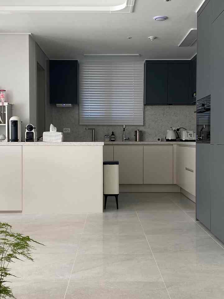 白と黒のモダンなアパートキッチン、窓に白いブラインドが設置された清潔感のあるインテリア