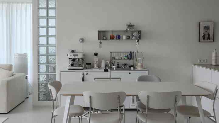 白とシルバーの色調のホームカフェ空間、ダイニングテーブルと椅子が配置されたモダンで清潔感のあるリビングインテリア