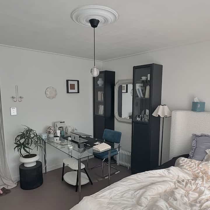 白と黒のトーンの寝室、モダンなデスクと本棚が配置された清潔感のある空間