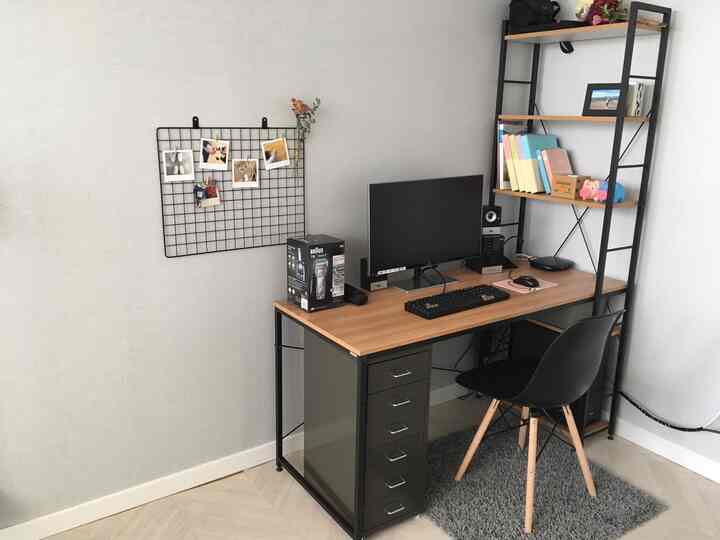 モノトーンと木目調が調和したホームオフィス書斎、デスクと本棚、コンピューターモニターが配置された整った作業環境