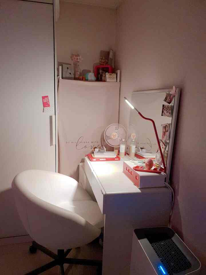 White-toned small room featuring a vanity desk with a white swivel chair in a tidy setup