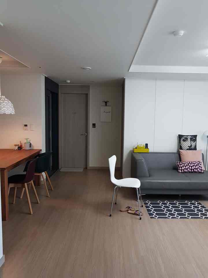 White and brown toned living room with modern sofa and dining table, featuring a simple and natural atmosphere
