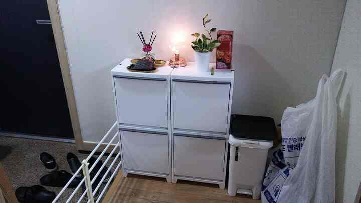 White-toned entrance area featuring Franco drawer units and a common recycling bin, showcasing neat storage ideas