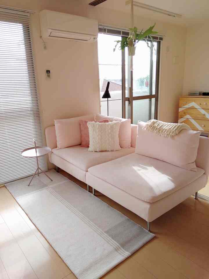 Bright living room with natural wood flooring featuring a light pink sofa and side table