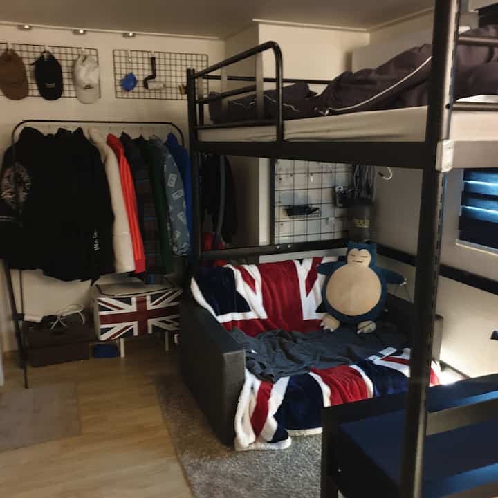 Monotone and black metal bunk bed with sofa in compact studio bedroom space