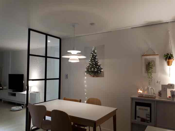 White and wood tone dining room featuring pendant light and Christmas poster with a cozy atmosphere