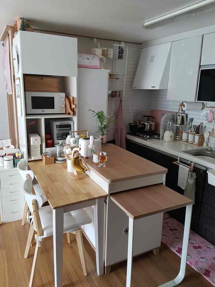 White and wood tone compact kitchen space featuring coffee accessories on table with cozy home cafe ambiance