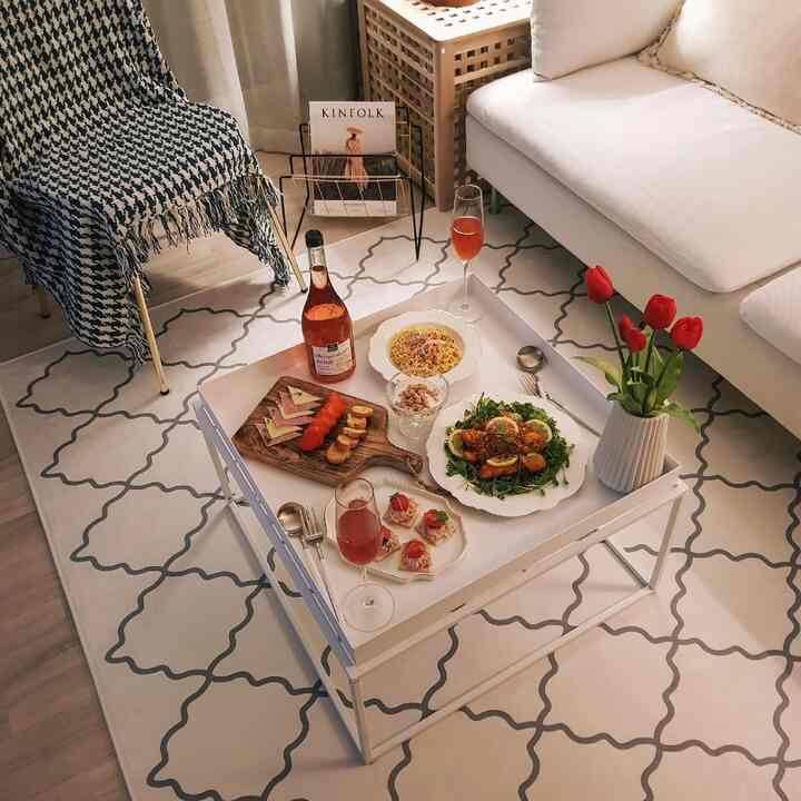 White and natural toned living room featuring white coffee table and sectional sofa, creating a cozy home cafe atmosphere