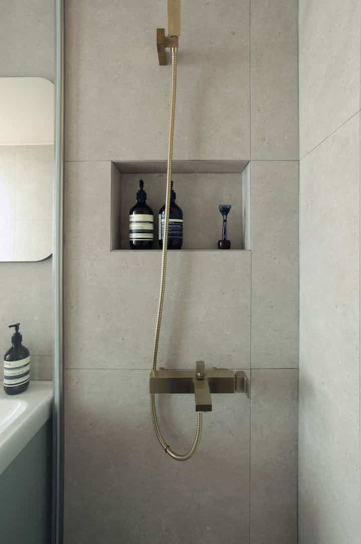 Natural beige tone bathroom with inset corner storage niche, minimalist and clean space