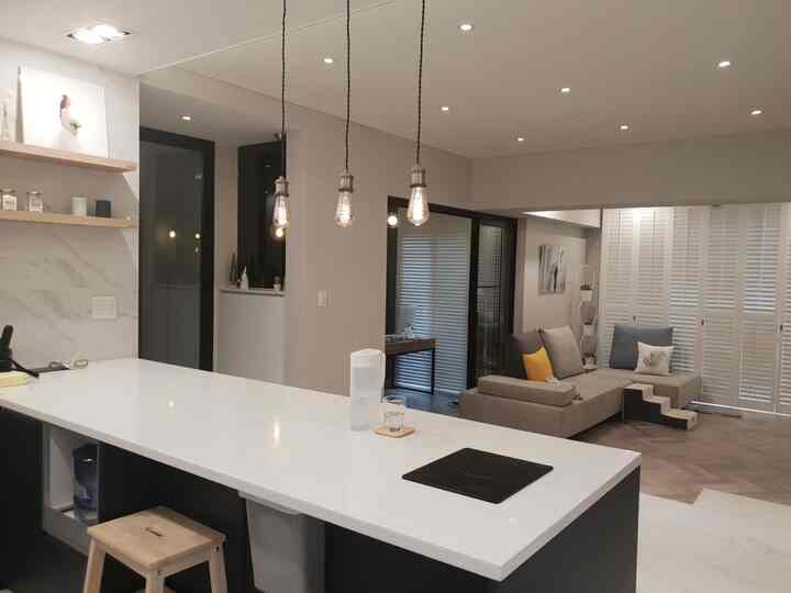 White and gray natural toned kitchen and living room with stairs and pendant lights in a modern cozy atmosphere
