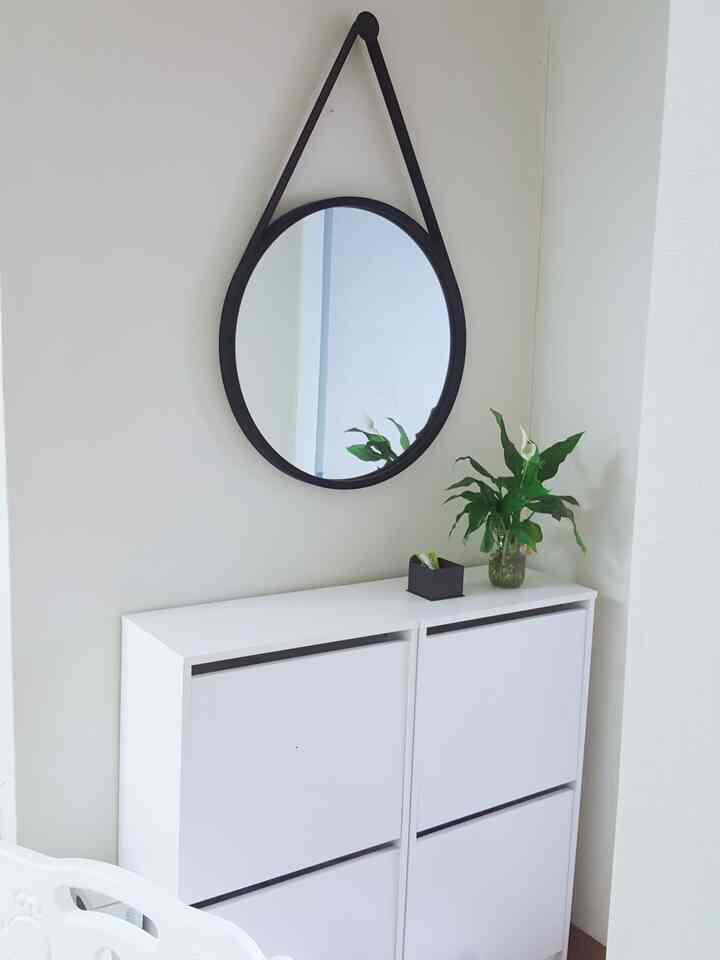 白と黒のモダンな玄関空間、イケアのシューズラックとストラップミラー、水耕栽培植物が配置された印象的なインテリア