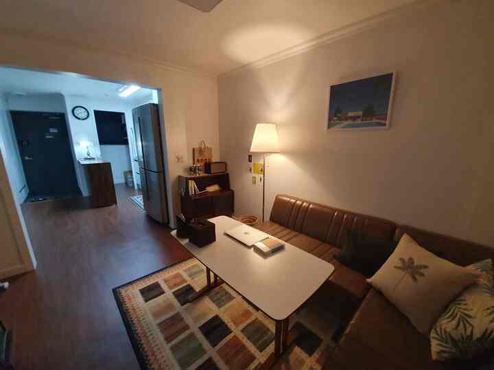 Warm brown and beige toned living room with leather sofa and floor lamp creating cozy atmosphere.