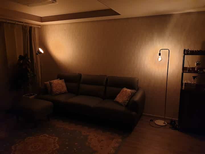 Brown-toned living room featuring a leather sofa, Persian carpet, and floor lamps creating a warm atmosphere