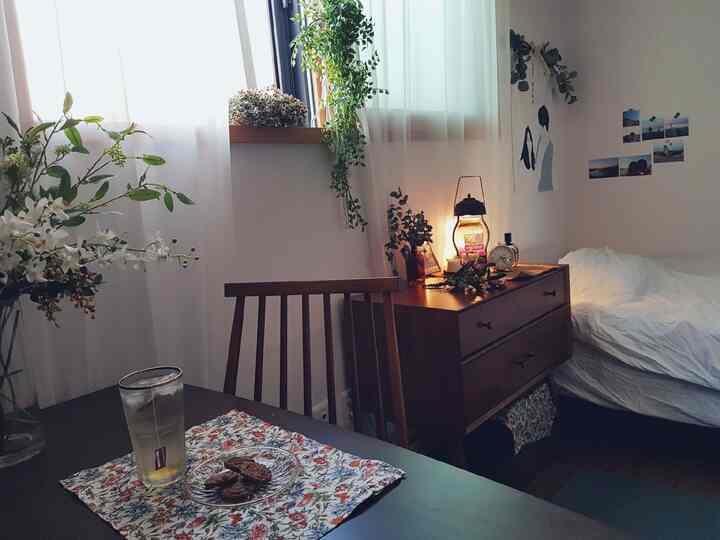 White and brown toned studio bedroom featuring a single table with tea and snacks, creating a cozy home cafe atmosphere