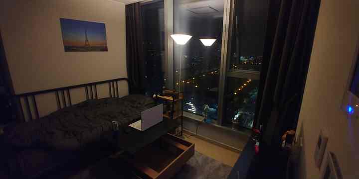 Small single household room in black and white tones featuring floor lamp and coffee table with a modern atmosphere