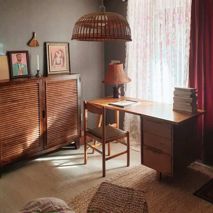 Cozy bedroom with warm wood tones and rattan lighting, featuring a natural-style desk and cabinet creating a serene atmosphere